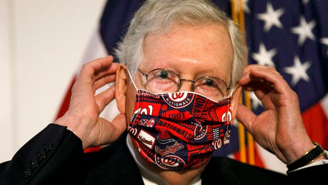 Senate Majority Leader Mitch McConnell of Ky., replaces his face mask after speaking at news conference after attending a Republican luncheon, Tuesday, July 21, 2020, on Capitol Hill in Washington.