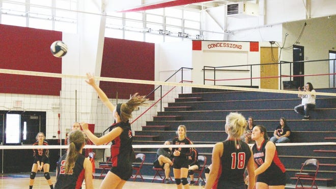 Freshman Abby Scritchfield, No. 4, makes the hit for the Red Devilettes, sending the ball soaring back to the visitors side.