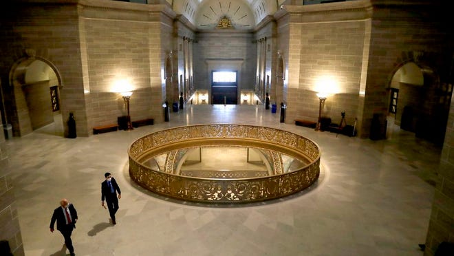 People wear protective masks as they walk in the rotunda at the state Capitol Monday, April 27, 2020, in Jefferson City, Mo. Members of the House returned Monday to begin debate on the budget for the upcoming fiscal year, a daunting task amid declining revenue because of the coronavirus.