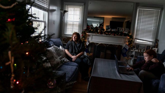 Eileen Carroll, left, sits for a portrait as her daughter, Lily, 11, attends school remotely from their home in Warwick, R.I, Wednesday, Dec. 16, 2020. When Carroll's other daughter tested positive for the coronavirus, state health officials told her to notify anyone her daughter might have been around. Contact tracers, she was told, were simply too overwhelmed to do it. It's the same story across the U.S., as a catastrophic surge in infections has made it difficult or impossible to keep up with the calls considered critical to controlling outbreaks.