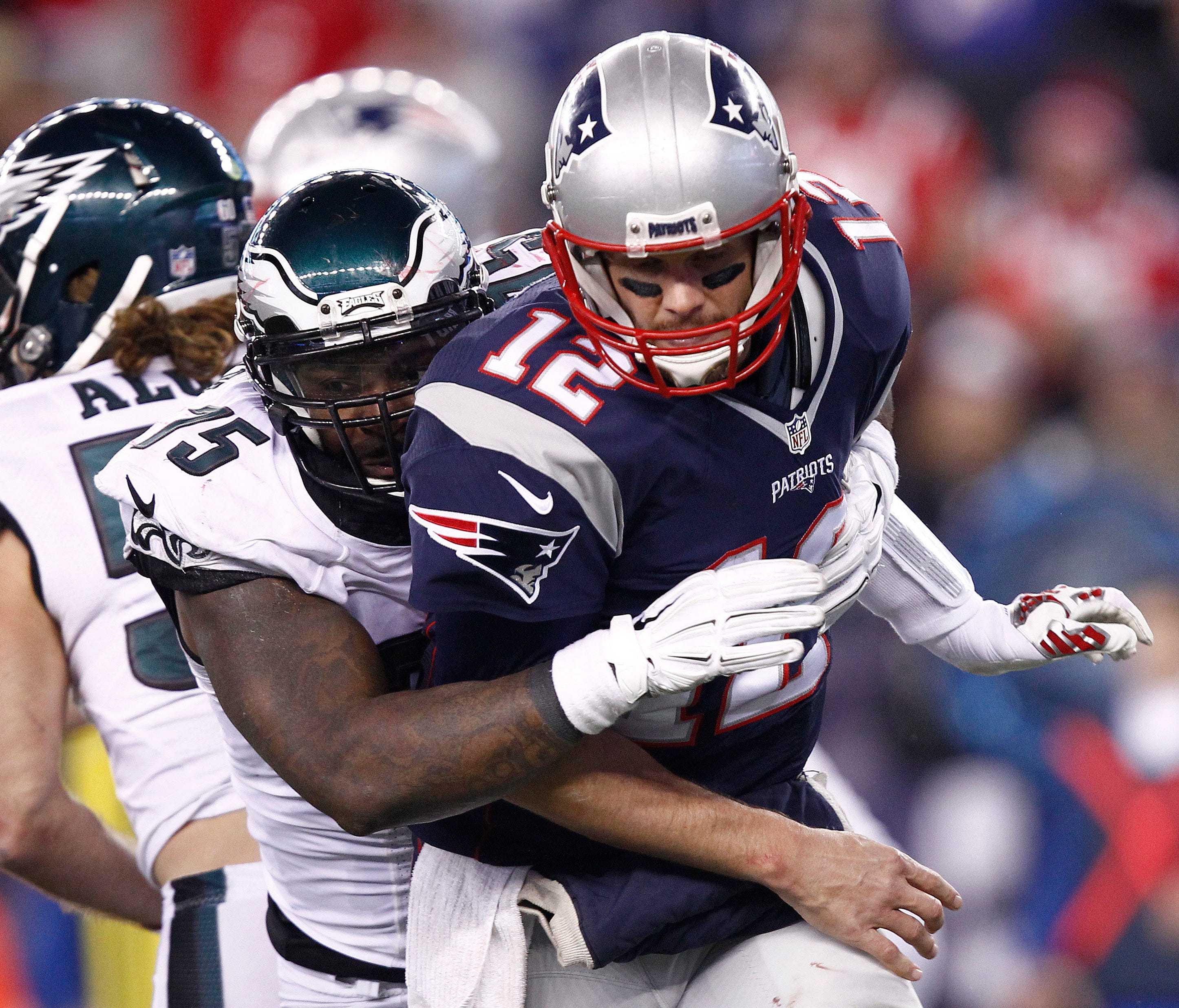 New England Patriots quarterback Tom Brady (12) is tackled by Philadelphia Eagles defensive end Vinny Curry (back) during the second half at Gillette Stadium.