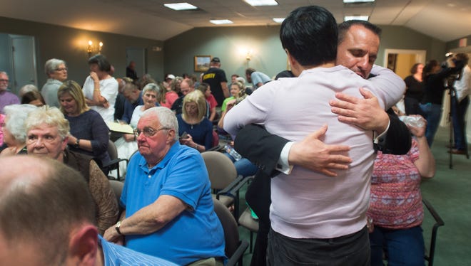 Jin Kim of Simpsonville hugs Police Chief Keith Grounsell during a city council meeting at Simpsonville City Hall on Tuesday, April 12, 2016.