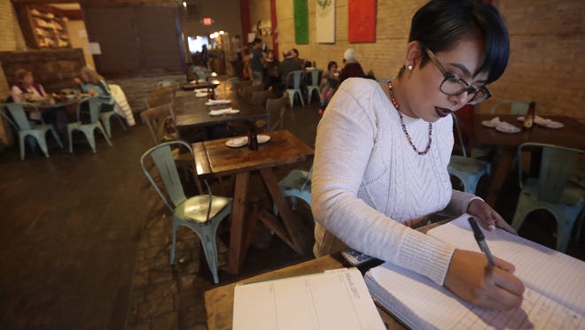 Manager Ana Reyes catches up on paperwork before Antojitos Mexicanos gets busy on Wednesday night in downtown Appleton.