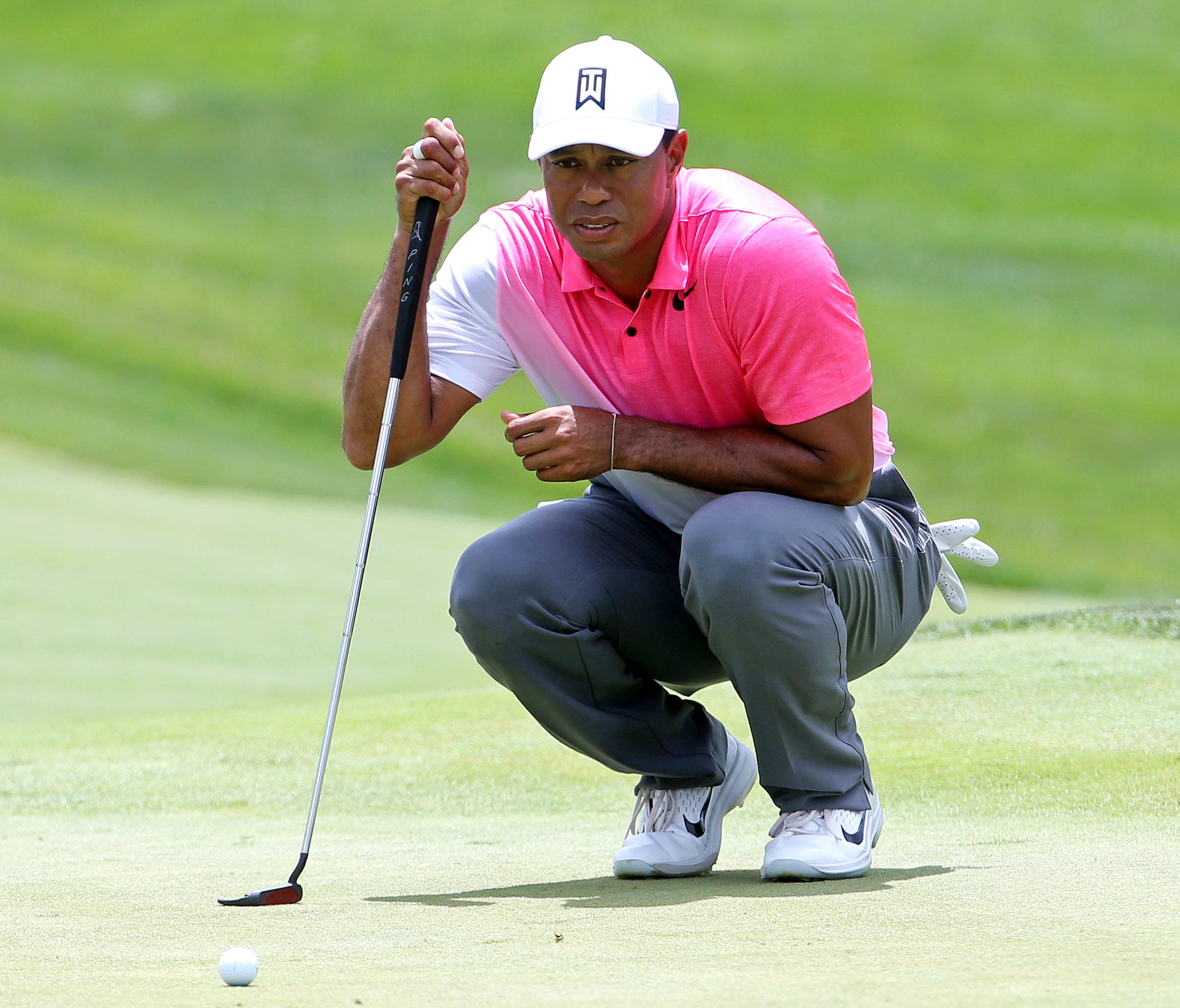 Tiger Woods lines up his putt on the first green during the first round of the Quicken Loans National golf tournament at TPC Potomac at Avenel Farm.
