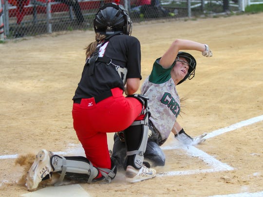 St. Joseph’s Sara Raubertas protects the plate as Cedar Creek’s Brianna Young tries to score during the Wildcats’ 6-4 victory on May 20.