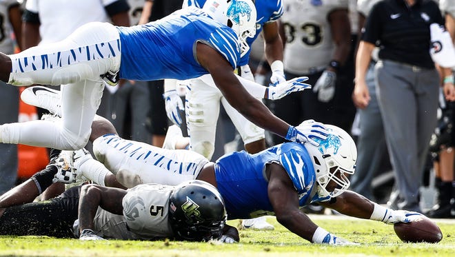 Memphis defender Genard Avery (right bottom) grabs a fumbled ball by UCF receiver Dredrick Snelson (left) bottom) during second quarter action of the the AAC Championship football game in Orlando, Fl., Saturday, December 2, 2017.