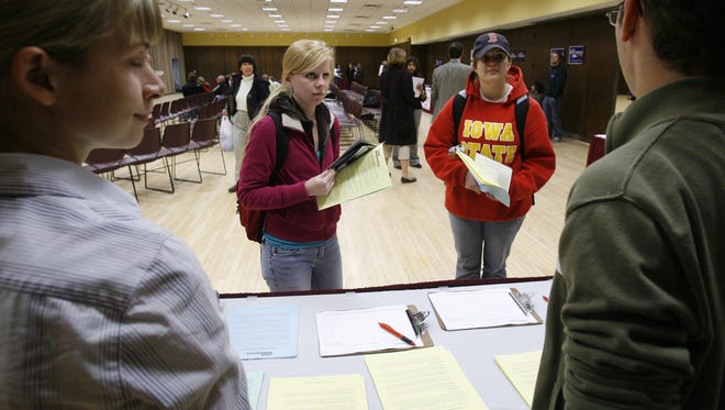 In this file photo from 2007, two Iowa State University students make their way around different tables to learn about the different presidential candidates.