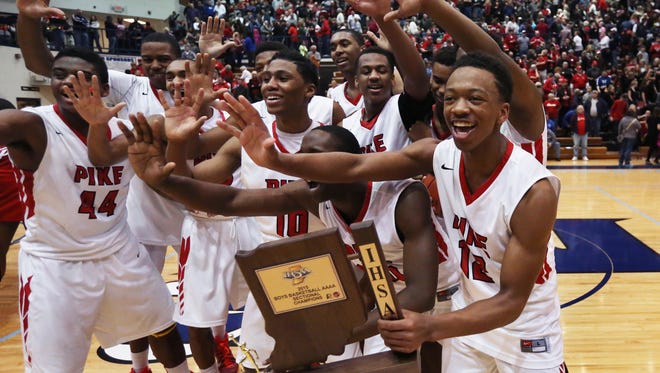 Pike's Justin Thomas (right), the team's high-scorer with 21 points, celebrates with his teammates after the school won its fifth consecutive sectional by beating the Class 4A No. 1 Southport Cardinals 49-48 in the Perry Meridian boys basketball sectional final on Saturday, March 7, 2015.