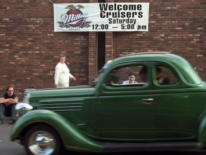 People watch a car pass by in the 1996 Classic Car