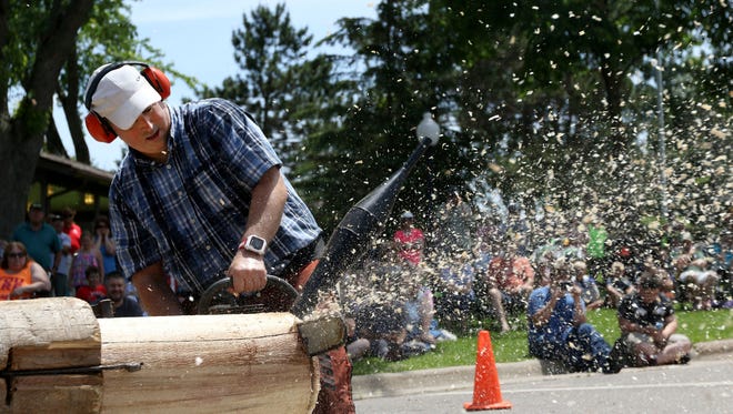 Travis Wells, a performer with the All American Lumberjack Show, saws through a log during Stratfiord Heritage Days in downtown Stratford Saturday, June 11, 2016. 