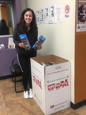 Ayla Gentiletti, a trainer from Anytime Fitness in Hopewell, accepts a donation for Toys for Tots. Anytime will offer a “fitness gift” to anyone who makes a donation of a new, unwrapped toy by Dec. 14. Members will receive a free training session and nonmembers will receive a free seven-day pass.