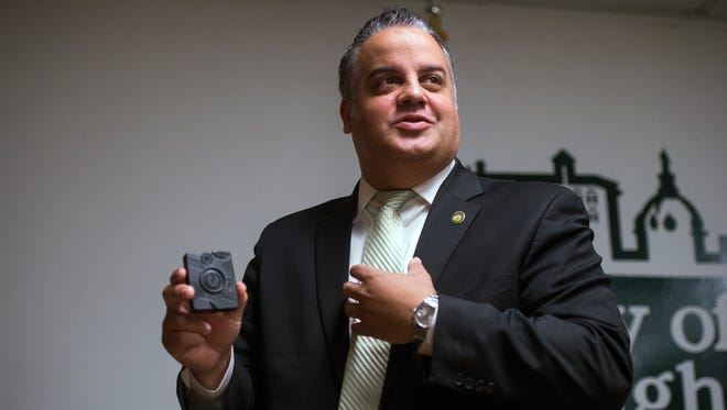 Binghamton Mayor Richard David holds one of 93 body cameras that will be deployed on Binghamton police officers during a news conference Tuesday at City Hall.
