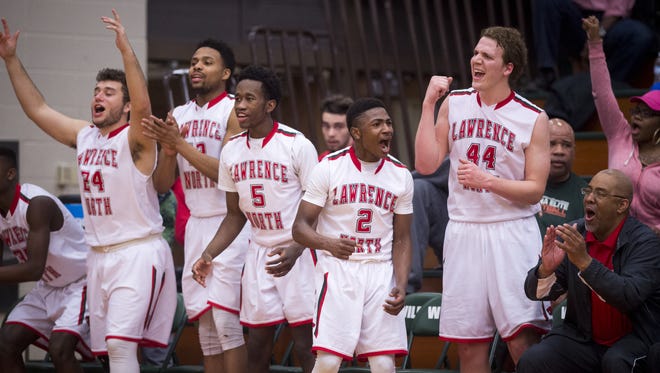 Players on the Lawrence North High School bench erupt Feb. 19, 2016, as their team extends their lead over Pike High School during the second half of a varsity basketball game at Lawrence North High School. Lawrence North won, 63-58.