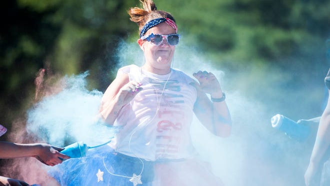 Charlie McSparron, of Sayre, gets pelted with colored powder during the Color of Independence 5K at Highland Park on Monday, July 4, 2016. Proceeds of the event benefitted the John Mack Foundation, a non-profit dedicated to fighting cardiac arrest deaths by donating automated external defibrillators within the community.