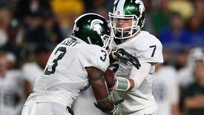 Michigan State quarterback Tyler O'Connor hands the ball to running back LJ Scott during MSU's win over Notre Dame Saturday.