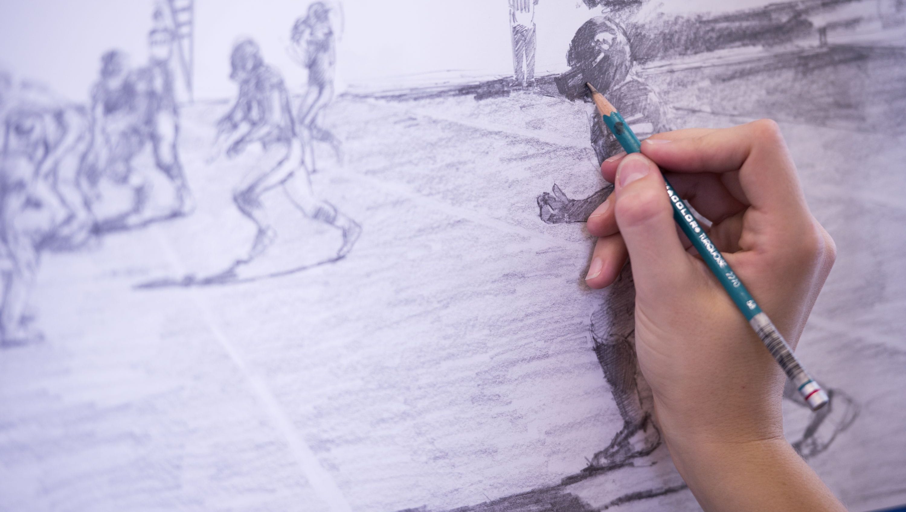 Elinor Krieger-Coble works on her football drawings in her studio in the Visual Arts Building. Elinor has been attending Iowa football games this season with a field pass to collect material to use to create an artist's interpretation of the gameday experience at Kinnick Stadium