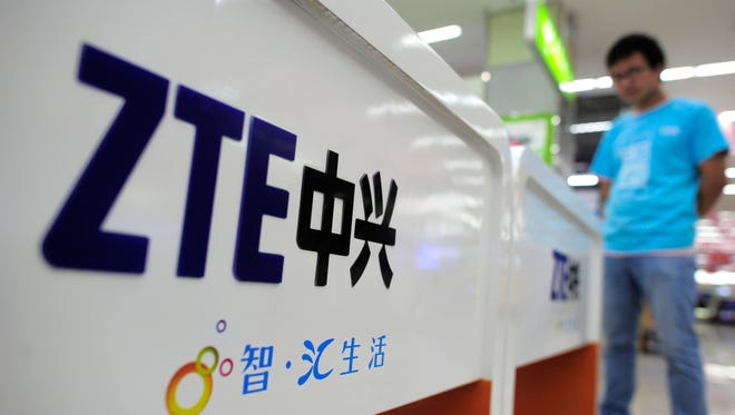 A salesperson stands at counters selling mobile phones produced by ZTE Corp. at an appliance store in Wuhan, in central China's Hubei province.