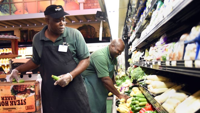 Corner Market employees DeLen Robinson, left, and Anthony Magee place produce in the store located off U.S. 98. If the plan to incorporate Bellevue succeeds, Corner Market would be in the new city.