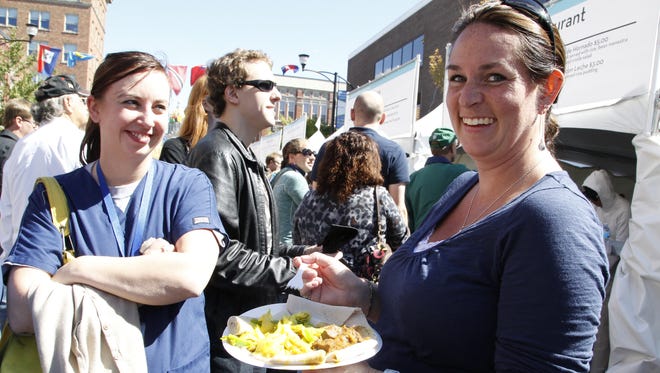 Taryn Betts, left, watches on as her friend Katey Olson samples an Ethiopian dish named Wot during the World Food Festival in the East Village in 2012.
