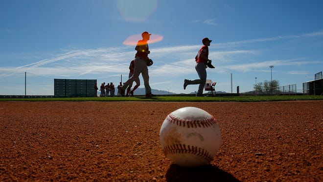Cincinnati Reds pitchers run off the field for the day at Cincinnati Reds spring training, Saturday, Feb. 20, 2016, in Goodyear, Arizona.