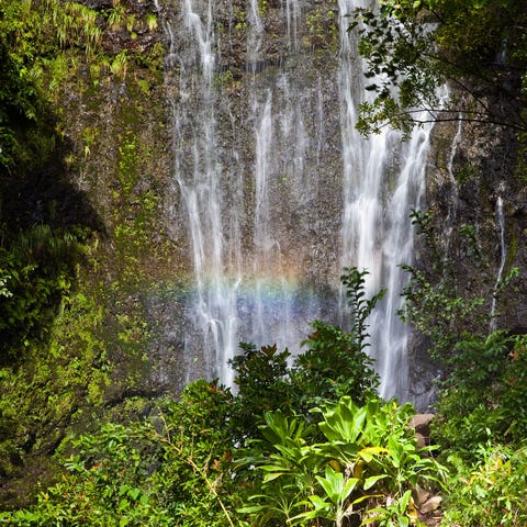 A couple enjoys Wailua falls in Hana on Maui.