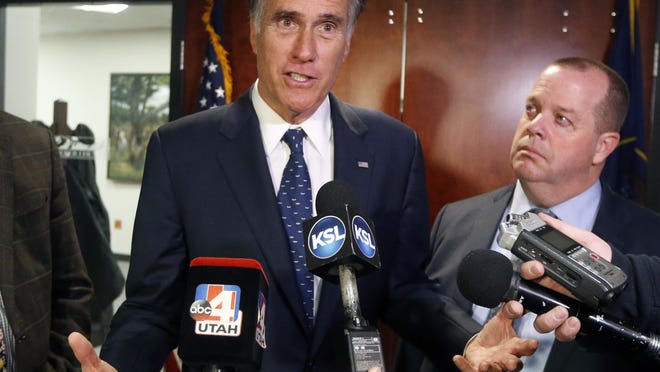 In this Friday Jan., 18, 2019 file photo, Utah Sen. Mitt Romney, left, speaks with reporters.