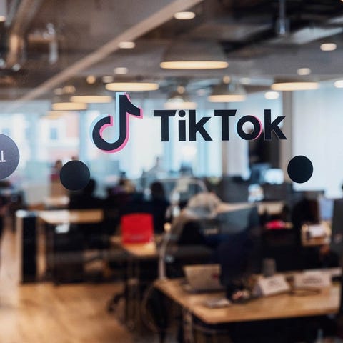 Glass door with TikTok logo on it, and office beyo