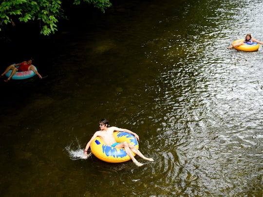 From left, Ivette Cruz, Robert Marks and Adeline Hines float down the Davidson River in the Pisgah National Forest in Brevard June 21, 2018.