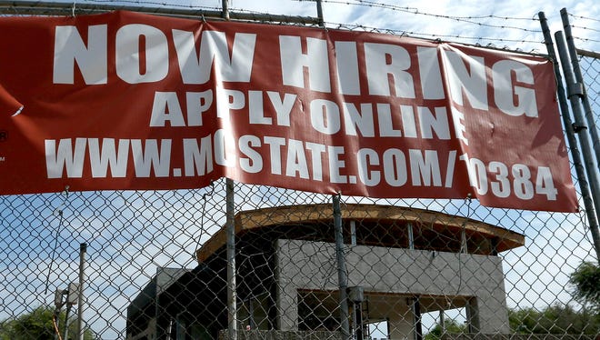 A "Now Hiring" sign hangs in front of a  McDonald's under construction in Tempe, Ariz.