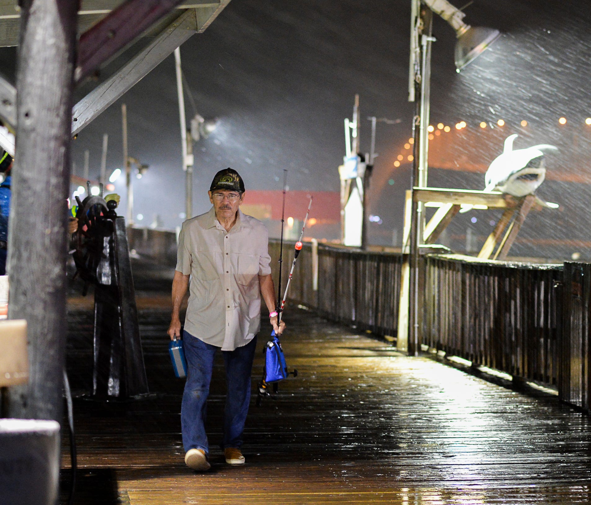 Rogelio Ortiz makes his way off the Pirate's Landing Fishing Pier as rain from Hurricane Harvey falls on Thursday, Aug. 24, 2017, in Port Isabel, Texas.