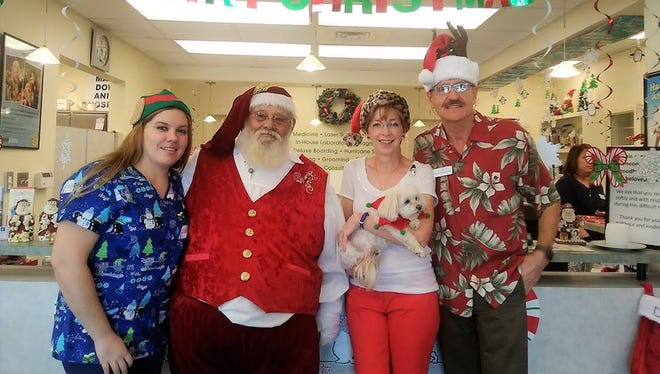 Dr. Stacy Wapner, Dr. Robin Waters-Poderski and Dr. Karol Poderski pose with Santa during the Holiday Pet Photo fundraiser for House of Hope at Martin Downs Animal Hospital.