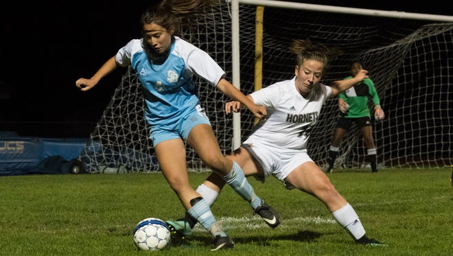 Essex's Aidan Bailey (14) and South Burlington's Olivia Dion (4) battle for the ball during the girls soccer game between the South Burlington Wolves and the Essex Hornets at Essex High School on Saturday night.