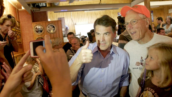 2012 presidential candidate Rick Perry, poses for a picture during a stop at the Hamburg Inn No. 2 in Iowa City on Aug. 15, 2011.