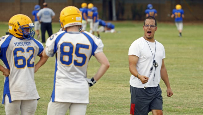 Tempe Prep head coach Josh Brittain works with his team Tuesday, September 20, 2016 in Tempe. Brittain has cerebral palsy, the result of suffering a brain hemorrhage at birth.