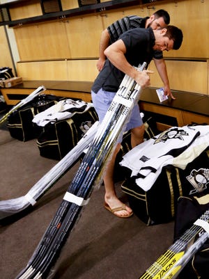 Pittsburgh Penguins forward Chris Kunitz (Ferris State) looks over a bundle of hockey sticks June 16, 2016.