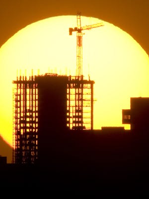 The sun sinks behind the downtown Phoenix skyline.