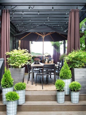 This outdoor dining room featured on Hayneedle.com showcases how the designer Brian Patrick Flynn turned the lackluster entry of his mountain house into an architectural masterpiece with the addition of a pine pergola. To ensure a seamless look between the home’ exterior and the pergola, Flynn painted them both with the same shade of black. Opaque stain in a medium brown tone was used on the deck surface to break up the otherwise all black look and also showcase the grain of its wood planks.