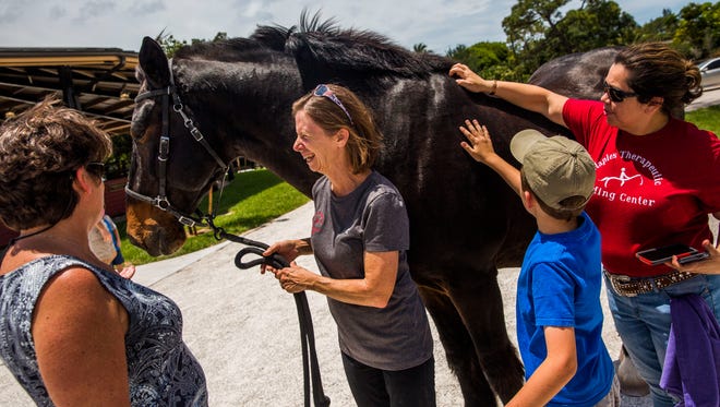 People say goodbye to riding horse Ted during a retirement ceremony at Naples Therapeutic Riding Center on Sunday, April 30, 2017. The two horses, Pickett and Ted, have 18 years combined service at the center and are retiring to a ranch in Texas.