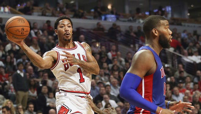 Bulls guard Derrick Rose (1) fakes Pistons forward Greg Monroe (10) and then makes a pass during the second quarter of the Pistons' 102-91 loss Monday in Chicago.