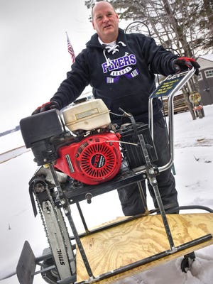 Chuck Zwilling stands next to a custom chainsaw rig Tuesday, Jan. 2, at Green Prairie Fish Lake near Little Falls. Zwilling and his siblings will use the saws to cut a 110-meter circular chunk of ice free in an attempt to create the world's largest spinning ice carousel as a fundraiser on Saturday. 