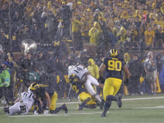 MSU's Brian Lewerke is tackled by U-M's David Long in a rain-soaked win for the Spartans at Michigan Stadium on Oct. 7, 2017.