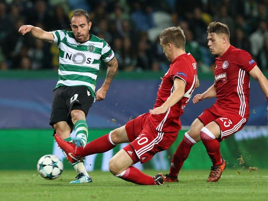 Sporting's Bruno Cesar, left, scores his side's second goal besides Olympiakos' Bjoern Engels, center, and Olympiakos' Leonardo Koutris during a Champions League, Group D soccer match between Sporting CP and Olympiakos at the Alvalade stadium in Lisbon, Wednesday Nov. 22, 2017. (AP Photo/Armando Franca)
