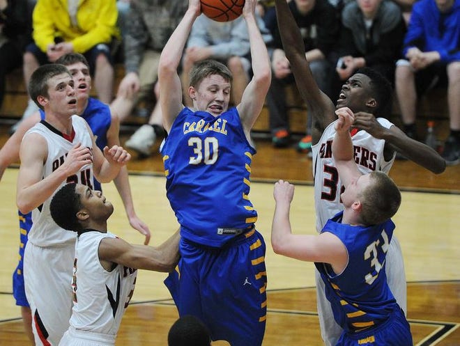 Michael Bruns pulls down a rebound for Carmel. in a semi-final game of the Noblesville sectional Friday March 7, 2014