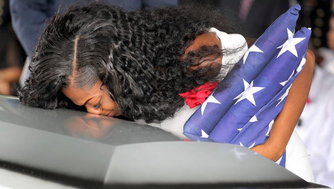 Myeshia Johnson, the widow of Army Sgt. La David Johnson, kisses her husband's casket during the funeral service at the Hollywood Memorial Gardens in Hollywood, Fla., on Oct. 21, 2017. Sgt. Johnson was killed with three other colleagues in an ambush by extremists in Niger on Oct. 4.
