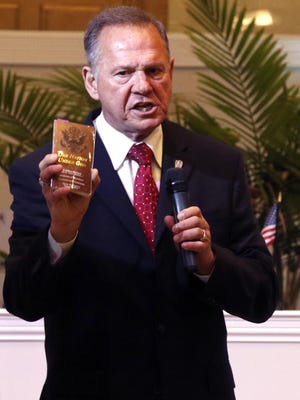 Alabama Supreme Court Chief Justice Roy Moore holds a copy of the Constitution as he speaks to the congregation of Kimberly Church of God in this file photo.
