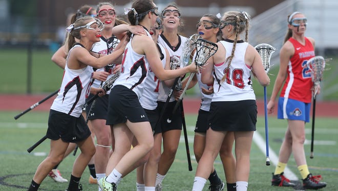 Penfield's Hannah Spaan is mobbed by teammates as they celebrate her first-half goal that opened the scoring during their Section V Class A semi final game against Fairport on Thursday, May 21, 2015.