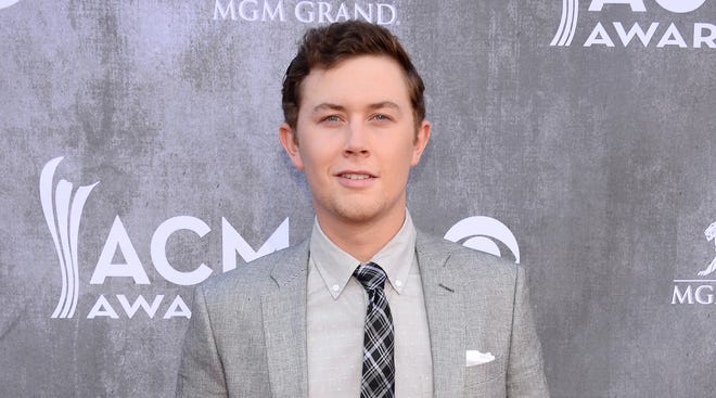 This April 6, 2014 file photo shows singer Scotty McCreery at the 49th annual Academy of Country Music Awards in Las Vegas. Police say McCreery was the victim of an early morning home invasion near the campus of North Carolina State University, where he is a student. Raleigh Police spokesman Jim Sughrue says officers were called shortly before 2 a.m. Monday, May 5, to an apartment about a mile from campus. Three suspects armed with guns are reported to have taken wallets, cash and electronic items.