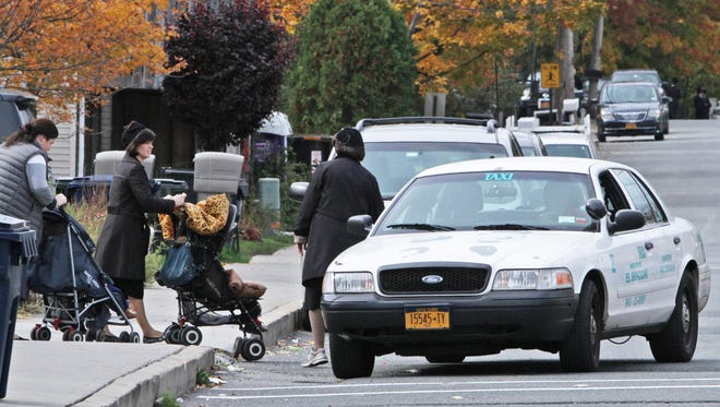 Women enter a taxi in New Square.