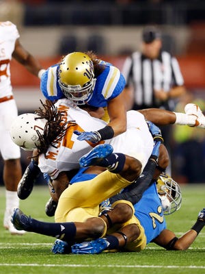 UCLA linebacker Eric Kendricks tackles Texas wide receiver Marcus Johnson during a game in September.