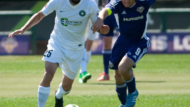 Saint Louis FC defender Brandon Barklage and Louisville City FC forward Matt Fondy and battle for the ball during last Saturday’s opener.